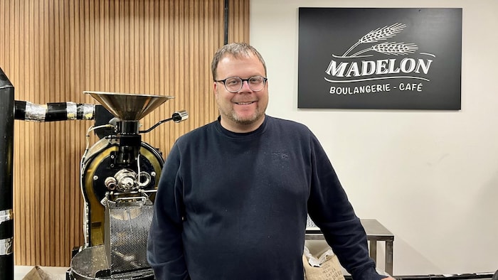 Jonathan Lapierre photographié devant une pancarte de la boulangerie Madelon.