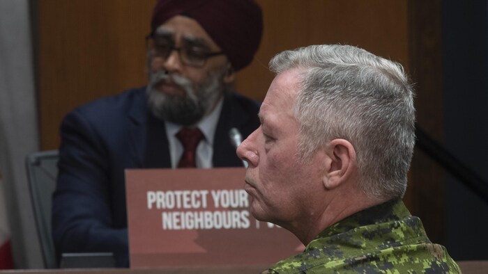 Jonathan Vance, de profil, se tient non loin du ministre Sajjan.