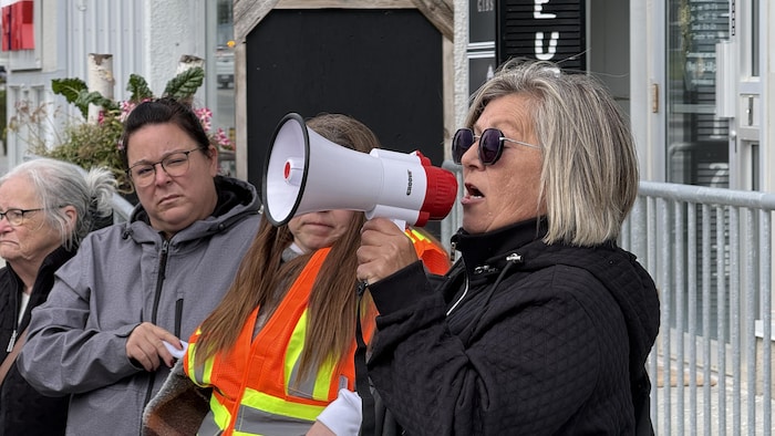 Josée Bélisle s'adresse à son public, mégaphone en main. 