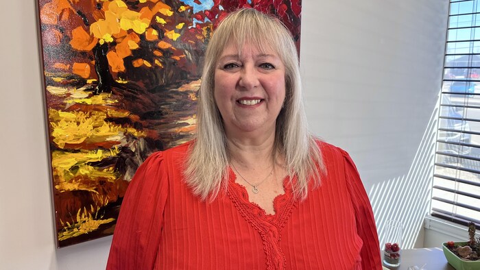 Une femme sourit à la caméra.