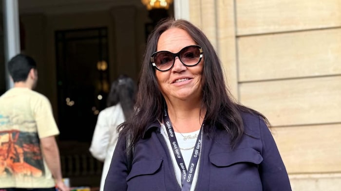 Portrait d'une femme portant des lunettes fumées.