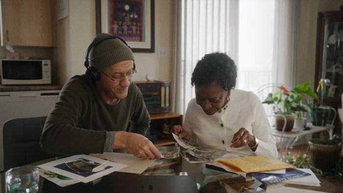 Un homme et une femme assis à une table regardent des photos.
