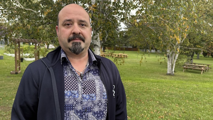Le directeur dehors devant une cour avec des tables.