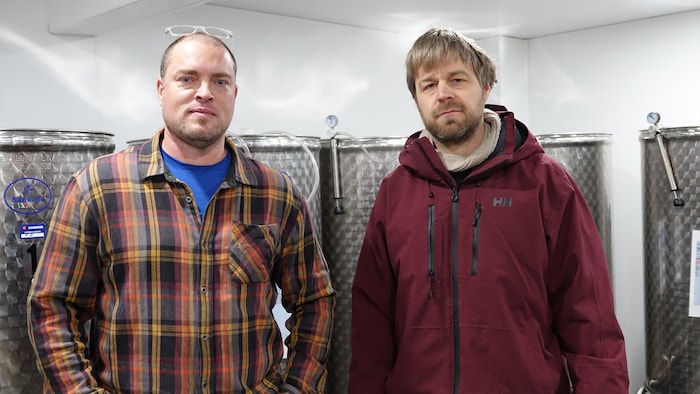 Joshua Burns (à gauche) et Louis Gauthier (à droite) devant des cuves de fermentation.