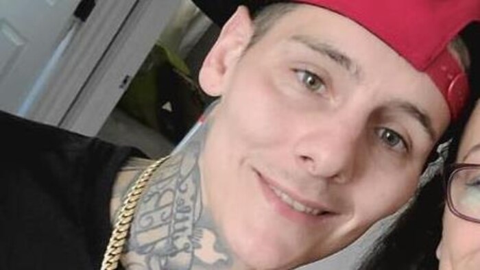 Joshua Martin portant une casquette rouge regarde la caméra en souriant.