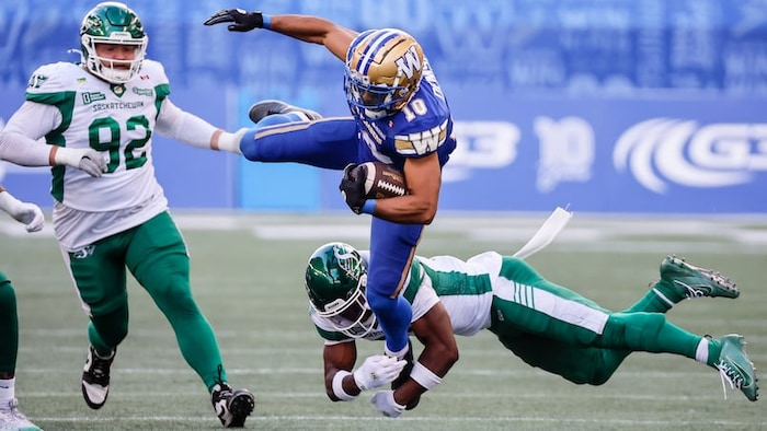 Des joeurs de shot des Blue Bombers et des Roughriders lors d'un match.