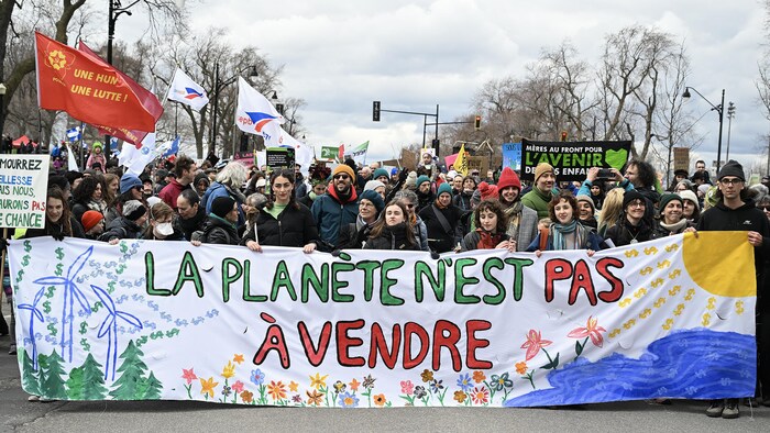 Des manifestants derrière une grande banderole qui porte la mention « la planète n'est pas à vendre ». 
