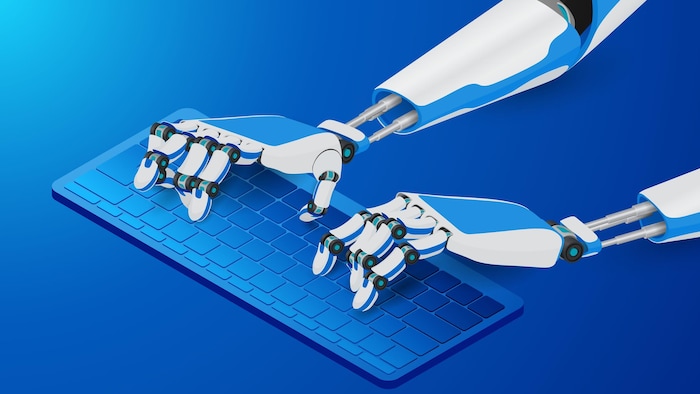 Les mains d'un robot tapent sur un clavier d'ordinateur. 