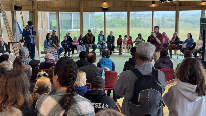 Des personnes sont assises, dont des enfants, en train d'écouter un orateur, le 21 juin 2025 à Regina.