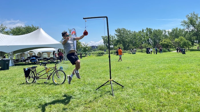 Un homme saute pour frapper une balle suspendue.