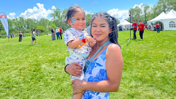 Verna Kanatsiak tient son fils dans ses bras.