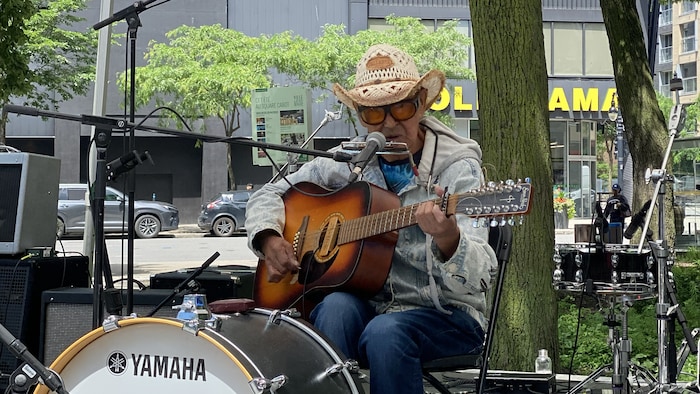 Willie Thrasher joue de la guitare et de la grosse caisse.
