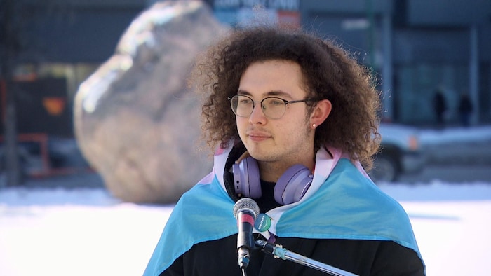 Molly Vanderwater, porte le drapeau transgenre comme un cape, dehors en mars au Manitoba.