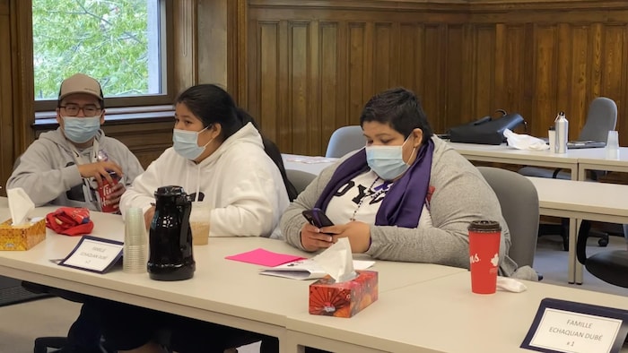 Personas sentadas en una mesa en la sala de un juzgado.