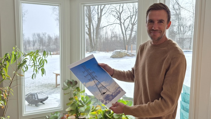 Jasmin Préville tient une affiche de pylône électrique. 