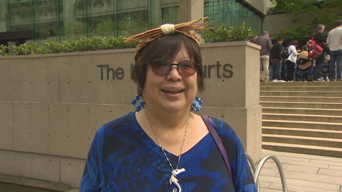 Judith Sayers sourit devant une cour.