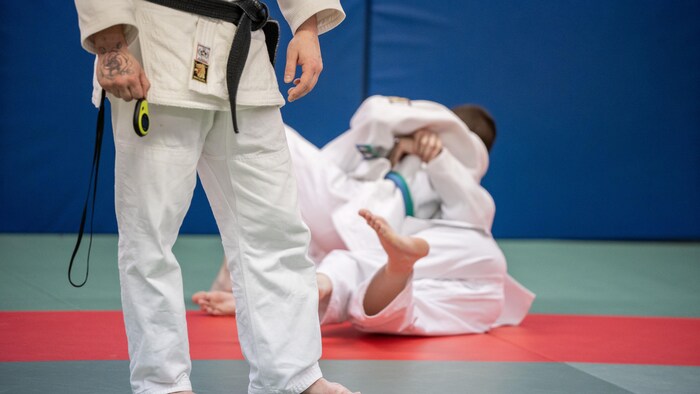 Des judokas à l’entraînement sur des tatamis.