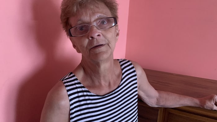 Une femme debout dans son appartement.