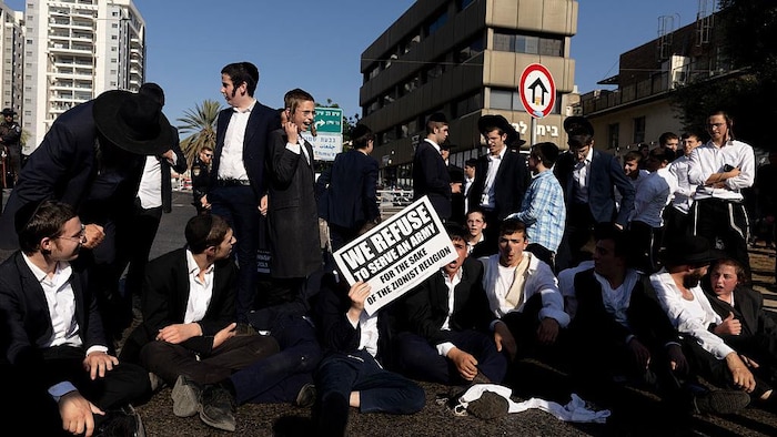 Des juifs ultra-orthodoxes protestent dans la rue.