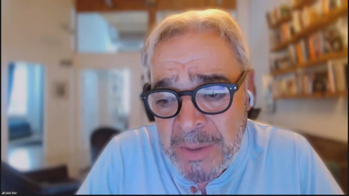 A man wearing glasses in interview with videoconferencing.