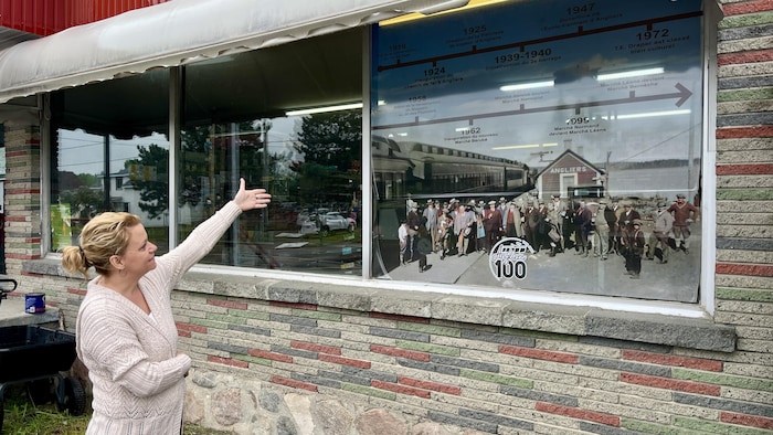 Un panneau dans la fenêtre d'un magasin décrit 100 ans d'histoire à Angliers.