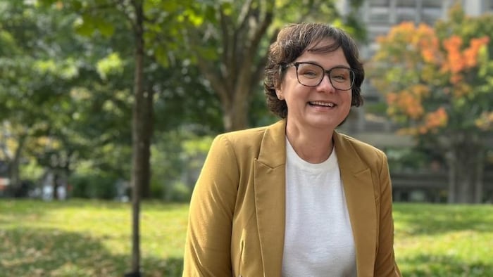 Julie Cailliau sourit devant un terrain gazonné.