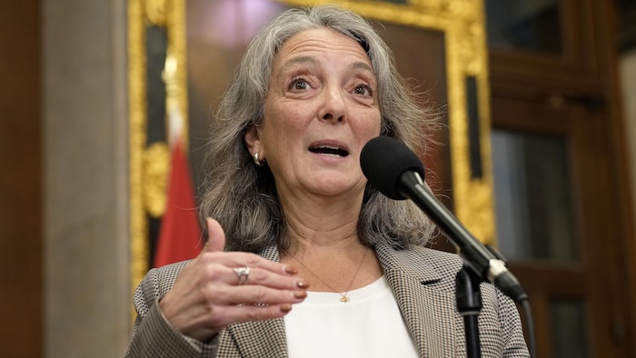 Une femme parle dans un micro.