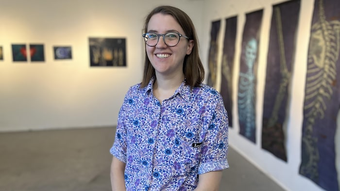 Julie Godin sourit au milieu d'une salle d'exposition.