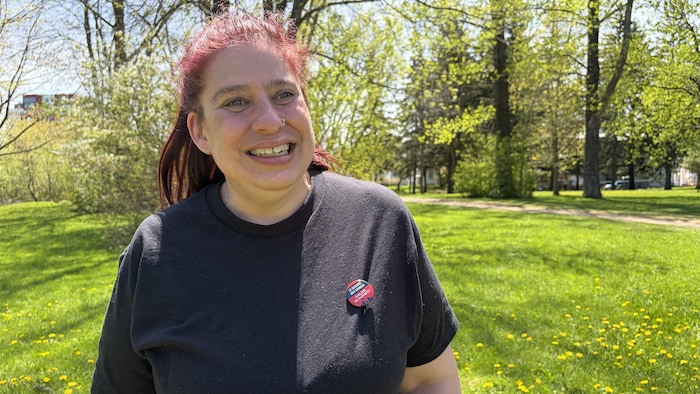 Dans un parc, Julie Lacroix sourit à la caméra.