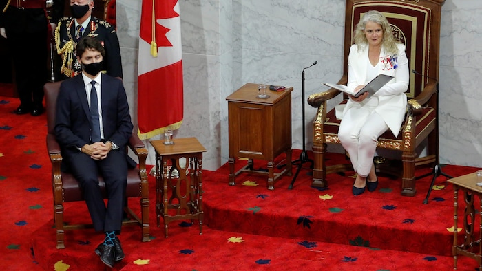 رئيس الحكومة الفدرالية جوستان ترودو يصغي، مرتدياً قناع الوجه الواقي، إلى حاكمة كندا العامة جولي باييت وهي تقرأ خطاب العرش أمام البرلمانيين في مجلس الشيوخ في أوتاوا في 23 أيلول (سبتمبر) 2020.