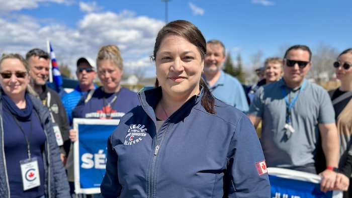 Portrait de Julie Séguin avec son équipe à l'arrière-plan.