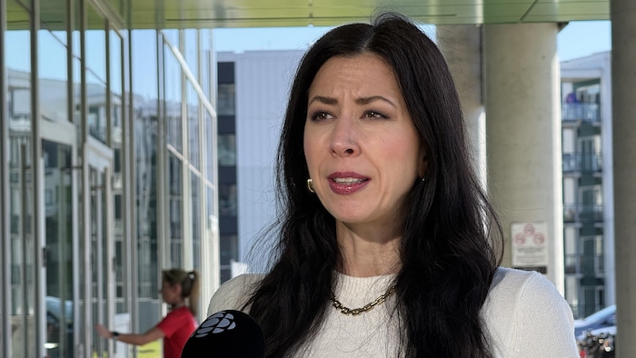 Julie St-Arnaud Drolet en entrevue avec Radio-Canada, à l'extérieur d'un immeuble.