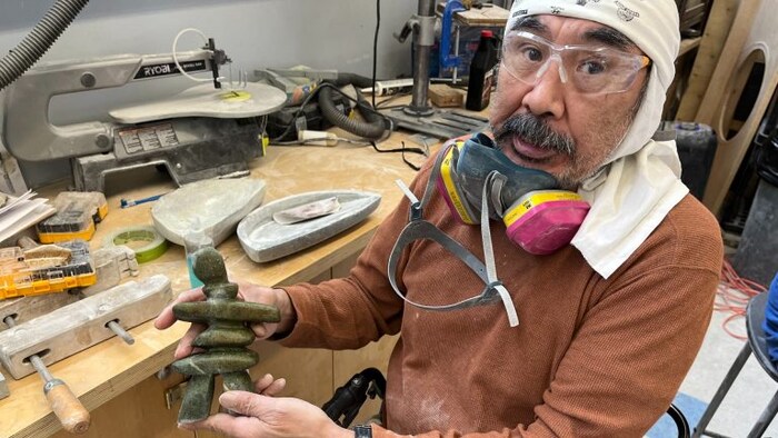 July Papatsie, a carving teacher at Isaruit, shows an inukshuk he’s been working on. 