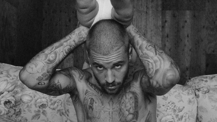 Le chanteur airs avec lad bébé dans les mains, au-dessus de sa tête.