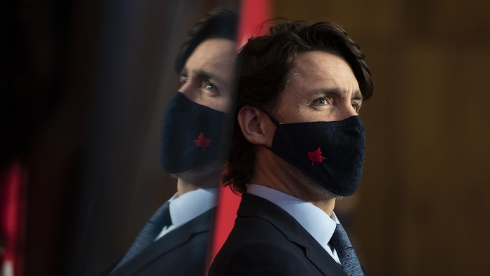 Justin Trudeau portant un masque orné d'une feuille d'érable.