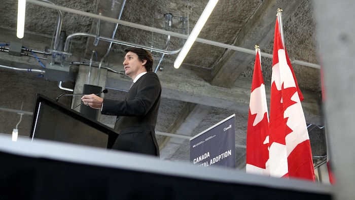 Justin Trudeau dans une salle prononce une allocution.