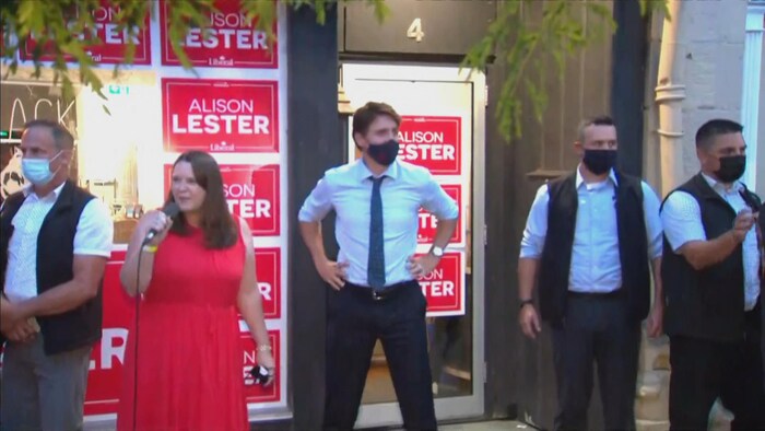 Justin Trudeau aux côtés de sa candidate qui parle dans un micro.