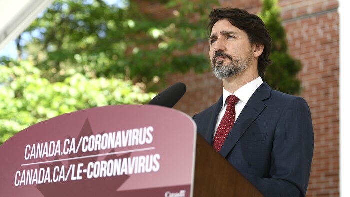 Le premier ministre Justin Trudeau debout derrière son lutrin durant une conférence de presse.