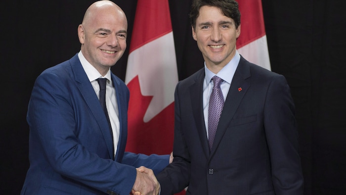 Les deux hommes se serrent la main.