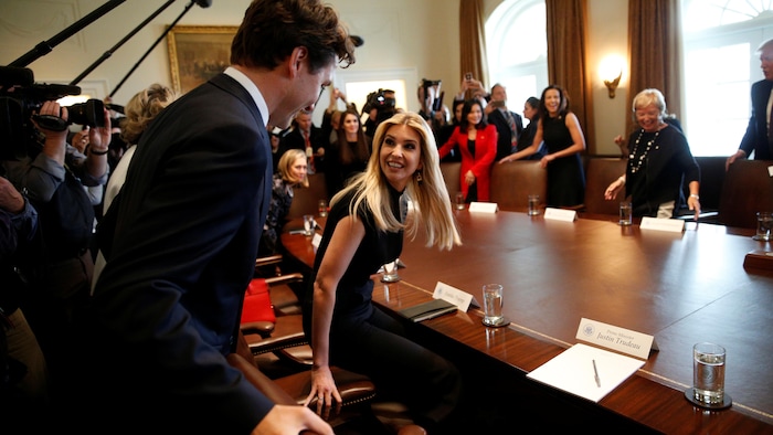 Justin Trudeau et Ivanka Trump s'assoient à une table.