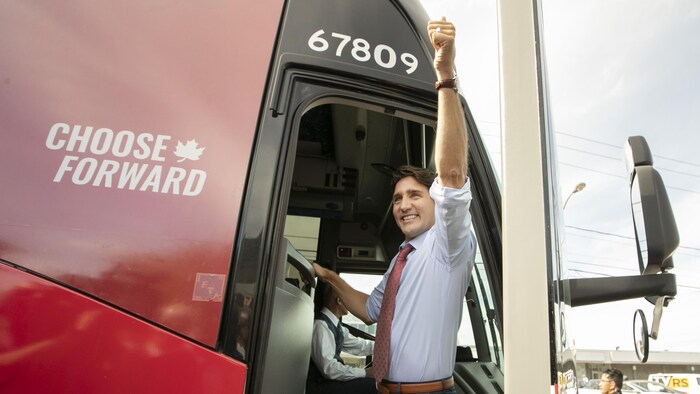 Justin Trudeau salue la foule depuis son autobus de campagne.