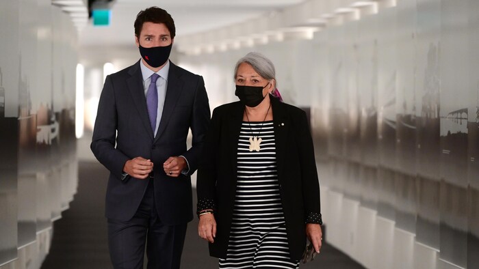 Justin Trudeau et Mary Simon marchent côte à côte en portant un masque.