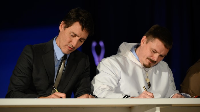 Le premier ministre Justin Trudeau, et celui du Nunavut, PJ Akeeagok, signent l’entente de dévolution, à Iqaluit, le 18 janvier.
