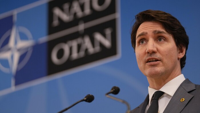 Justin Trudeau devant un sigle de l'OTAN.
