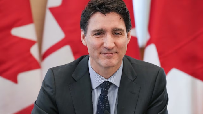 Justin Trudeau devant un drapeau canadien.