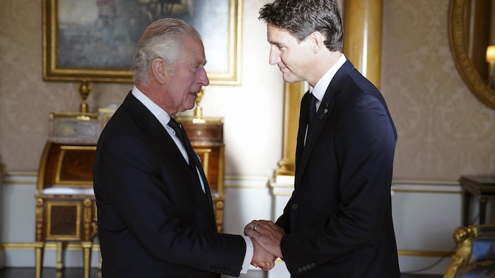 Charles III, à gauche, serre la main de Justin Trudeau, à droite.