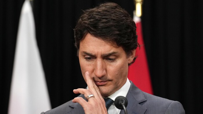 Justin Trudeau, la main posée sur le menton, en conférence de presse.