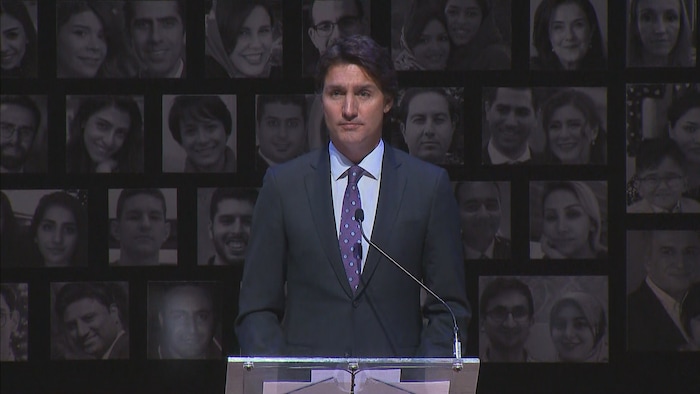 Justin Trudeau devant devant un pupitre.