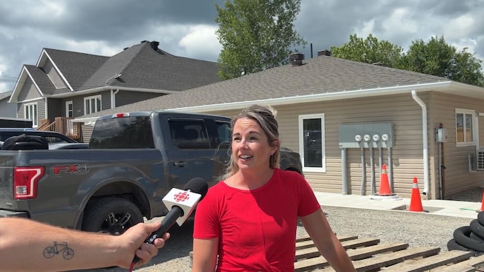 Kaarina Beavis qui parle dans le micro devant un chantier de construction. 