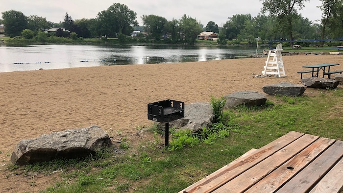 Une zone de sable fin fait face à la baie. On y trouve des tables et des barbecues.